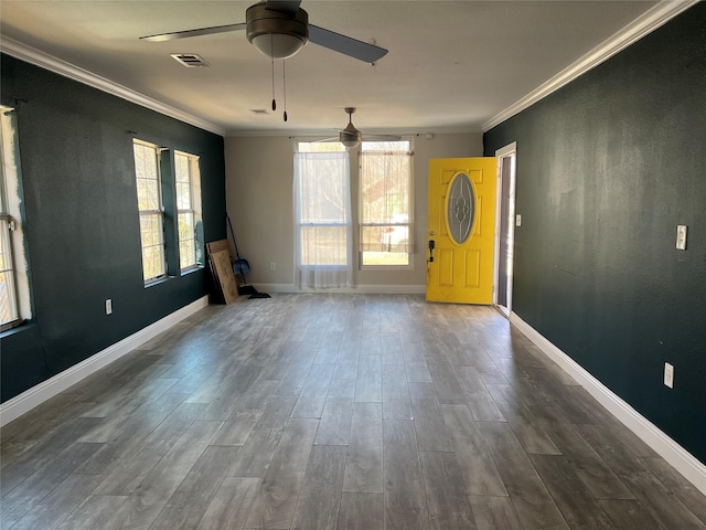 spare room featuring ornamental molding, visible vents, dark wood finished floors, and baseboards