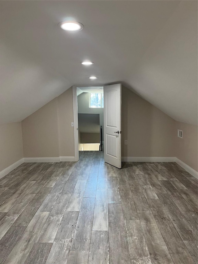 additional living space with visible vents, baseboards, and wood finished floors