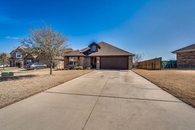 view of front facade featuring driveway, an attached garage, fence, a front lawn, and brick siding