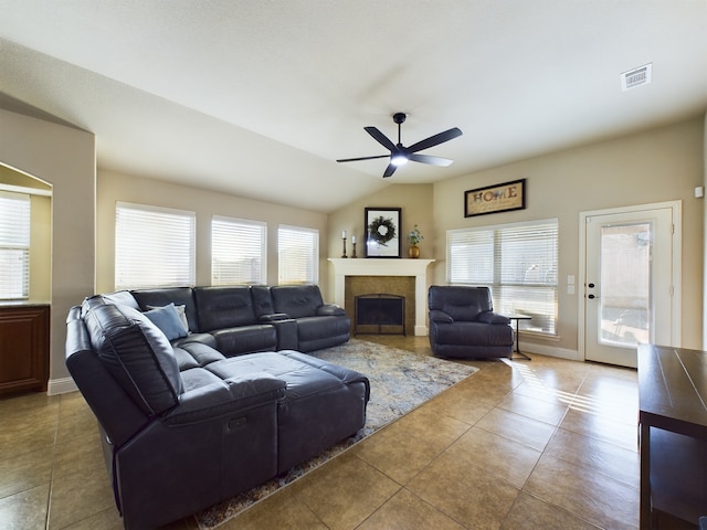 living room featuring a healthy amount of sunlight, a fireplace, visible vents, and vaulted ceiling