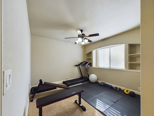 workout area with built in features, baseboards, visible vents, and a textured ceiling