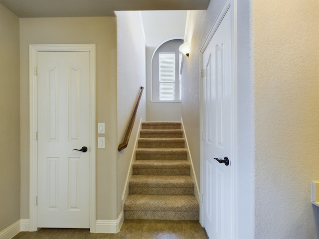 stairs featuring baseboards and tile patterned floors