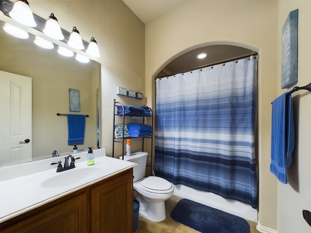 full bathroom with toilet, a textured wall, and vanity