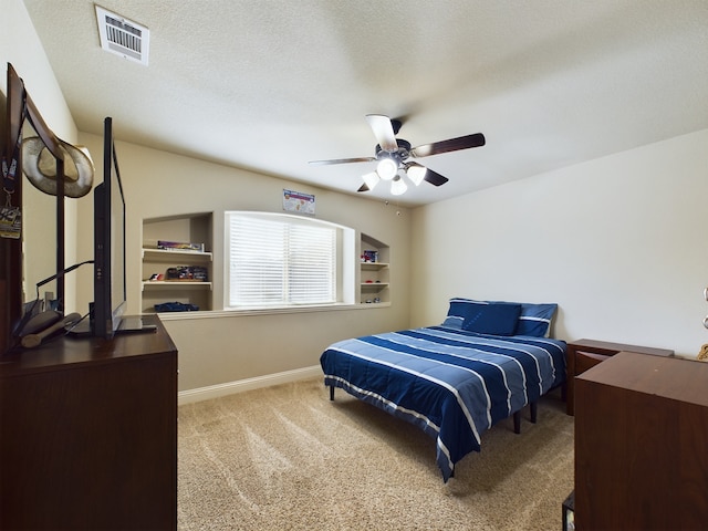 bedroom with light colored carpet, visible vents, ceiling fan, a textured ceiling, and baseboards