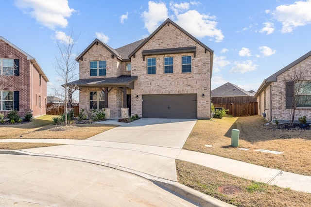 traditional-style home with an attached garage, fence, concrete driveway, and brick siding