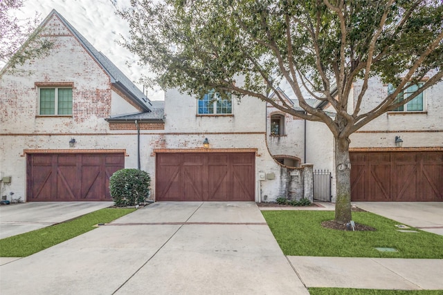 view of front of house with a garage, concrete driveway, and brick siding