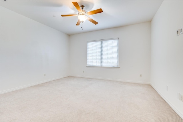 unfurnished room featuring light colored carpet, ceiling fan, and baseboards