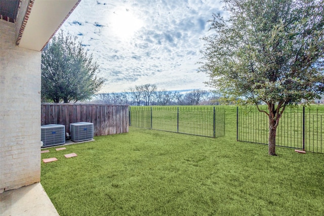 view of yard featuring central air condition unit and fence