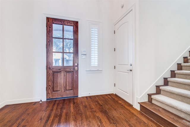 entrance foyer featuring baseboards, stairway, and dark wood-type flooring