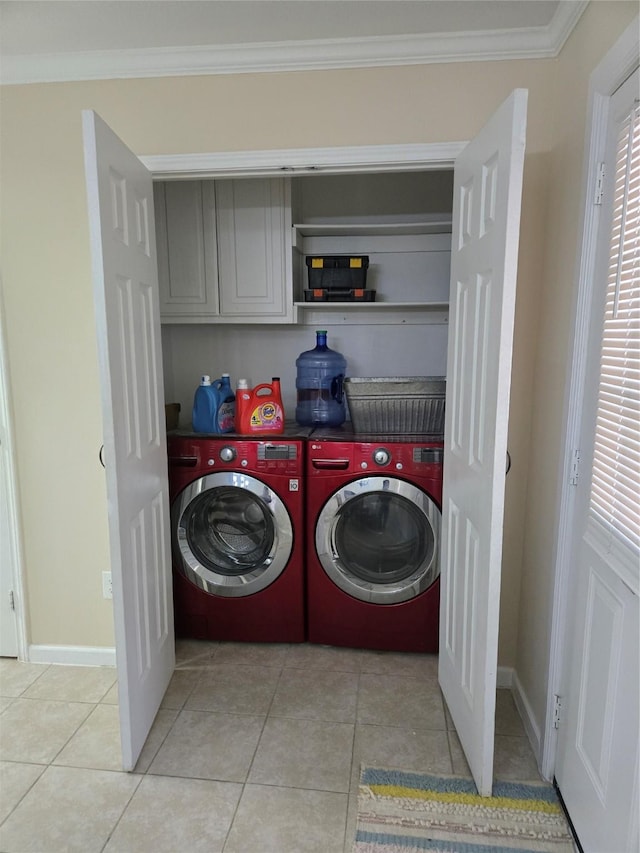 clothes washing area with light tile patterned floors, cabinet space, baseboards, ornamental molding, and independent washer and dryer