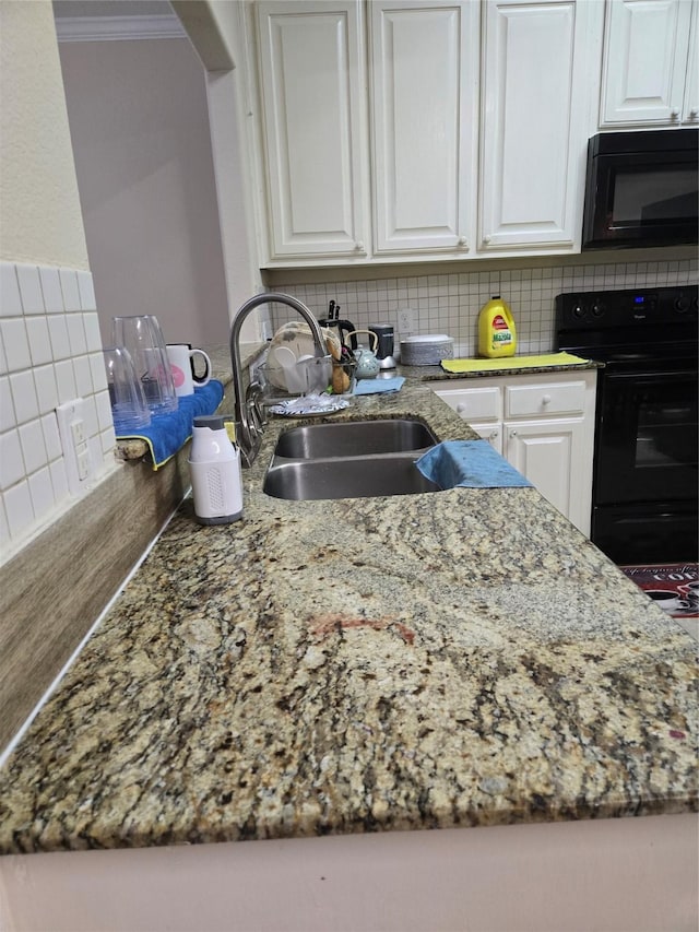 kitchen with decorative backsplash, ornamental molding, white cabinets, a sink, and black appliances