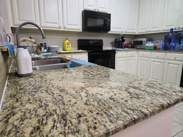 kitchen featuring black appliances, white cabinetry, decorative backsplash, and a sink