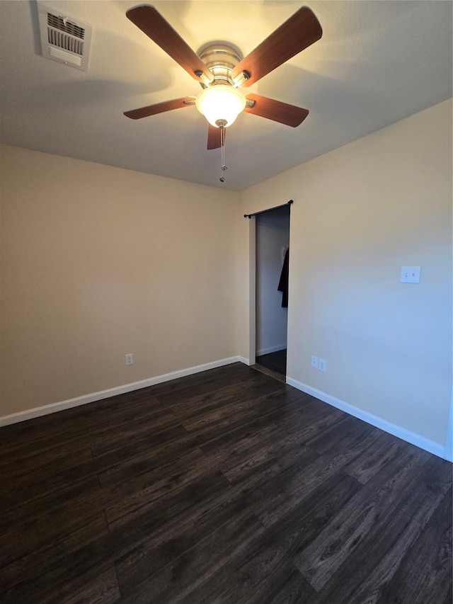 empty room with a ceiling fan, baseboards, visible vents, and dark wood-style flooring