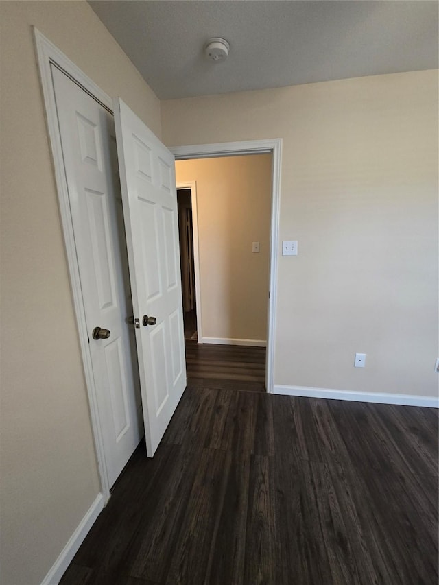 interior space featuring dark wood-style floors and baseboards