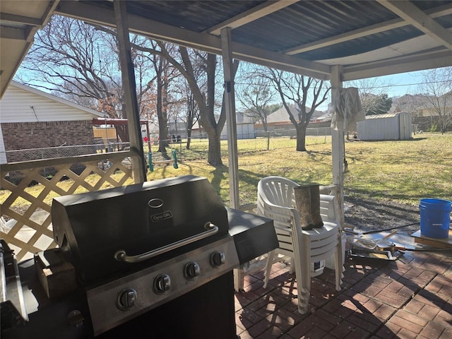 view of patio with an outdoor structure, fence, area for grilling, and a shed