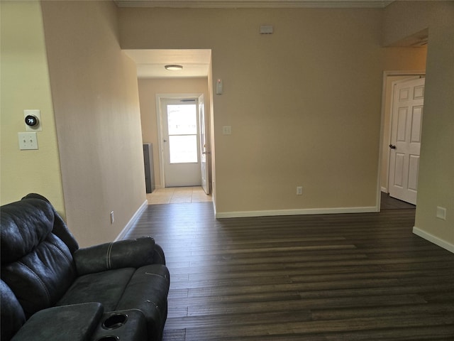 living room with crown molding, baseboards, and dark wood-style flooring