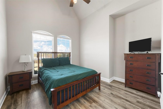 bedroom featuring a ceiling fan, baseboards, vaulted ceiling, and wood finished floors