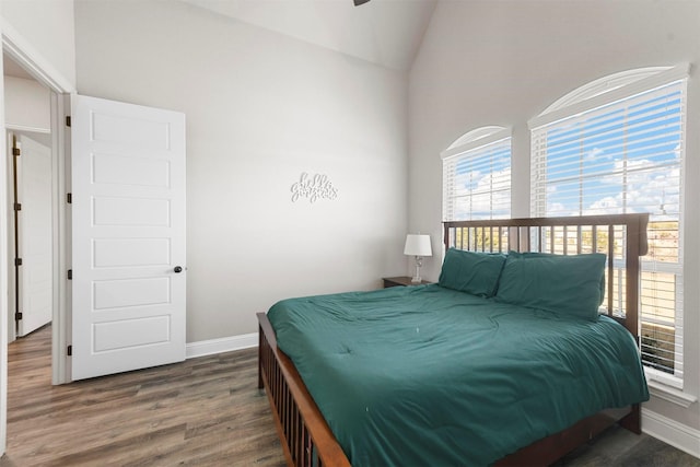 bedroom featuring baseboards, vaulted ceiling, and wood finished floors