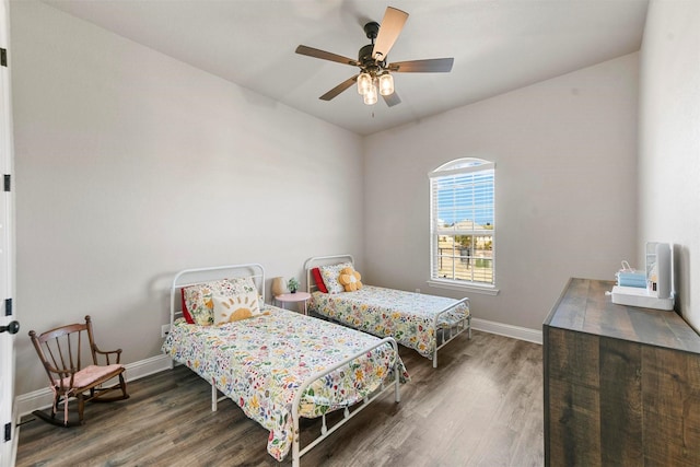 bedroom with wood finished floors, a ceiling fan, and baseboards