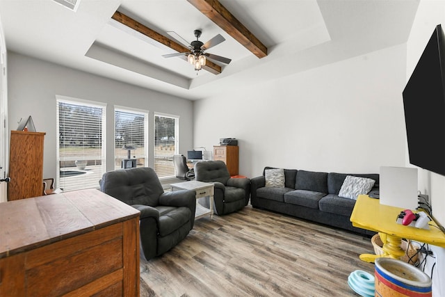 living room featuring ceiling fan, a raised ceiling, beamed ceiling, and wood finished floors