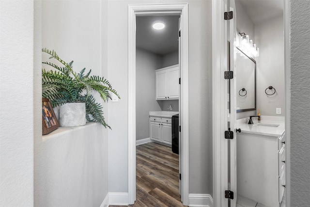 bathroom with wood finished floors, vanity, and baseboards