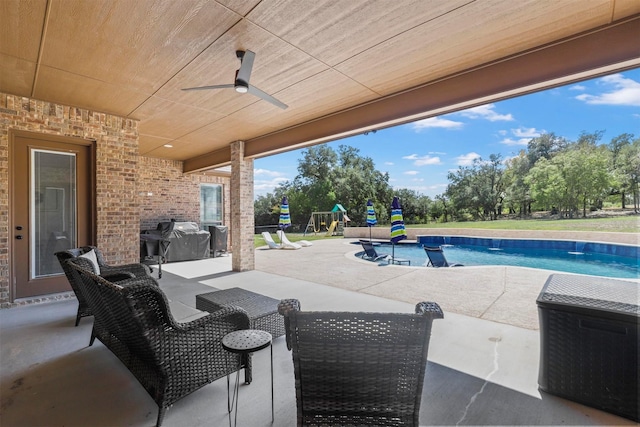 view of patio / terrace featuring ceiling fan, a playground, a grill, and an outdoor pool