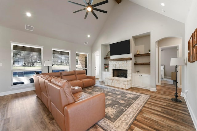 living area with a fireplace, visible vents, a wealth of natural light, and wood finished floors