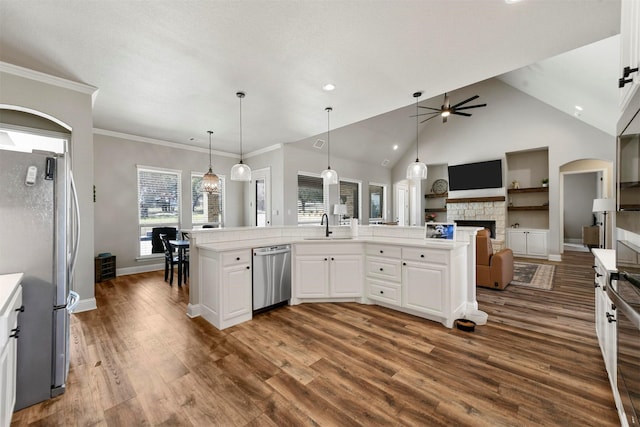 kitchen featuring white cabinets, dark wood-type flooring, stainless steel appliances, light countertops, and a sink