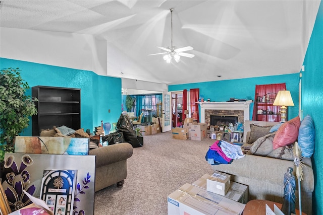 carpeted living area featuring a ceiling fan, lofted ceiling, and a stone fireplace