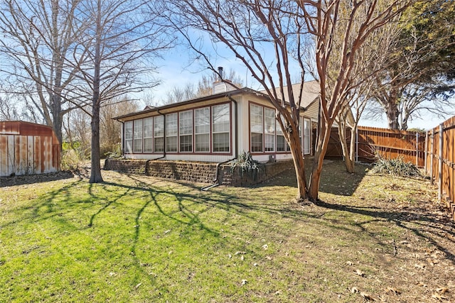 view of yard featuring a fenced backyard and a sunroom