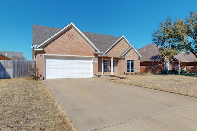 ranch-style home featuring an attached garage, brick siding, fence, concrete driveway, and a front yard