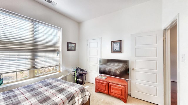 bedroom featuring visible vents and light carpet
