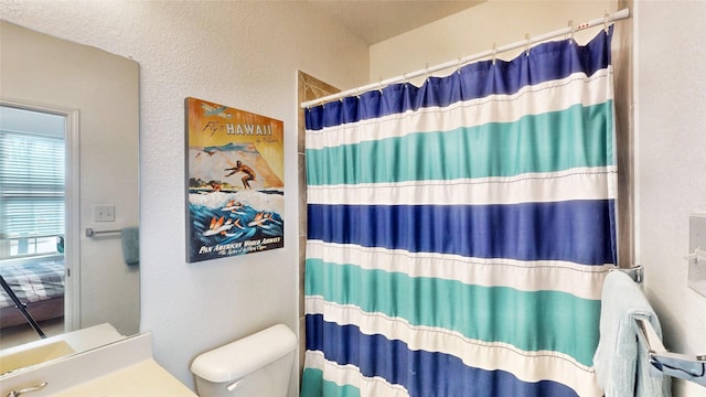 bathroom featuring toilet, a shower with curtain, and vanity
