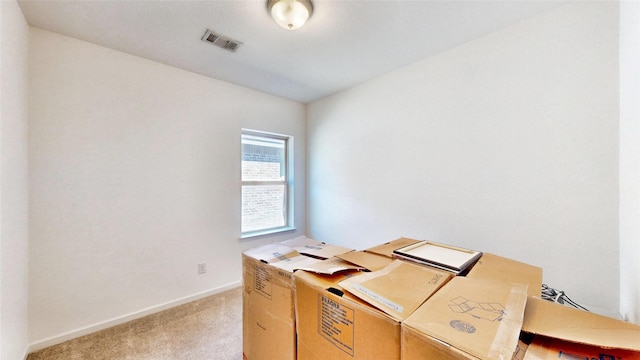 office area featuring baseboards, visible vents, and light colored carpet
