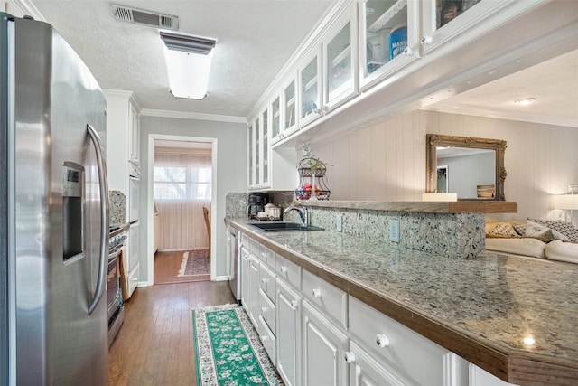 kitchen featuring visible vents, crown molding, appliances with stainless steel finishes, and a sink