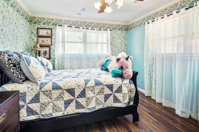 bedroom with crown molding, a ceiling fan, wood finished floors, baseboards, and wallpapered walls