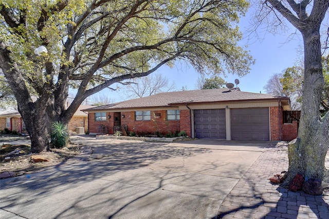 ranch-style home with a garage, brick siding, and driveway