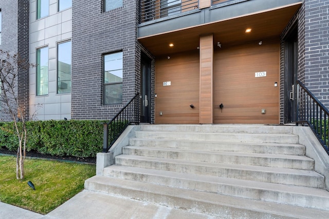 doorway to property featuring brick siding