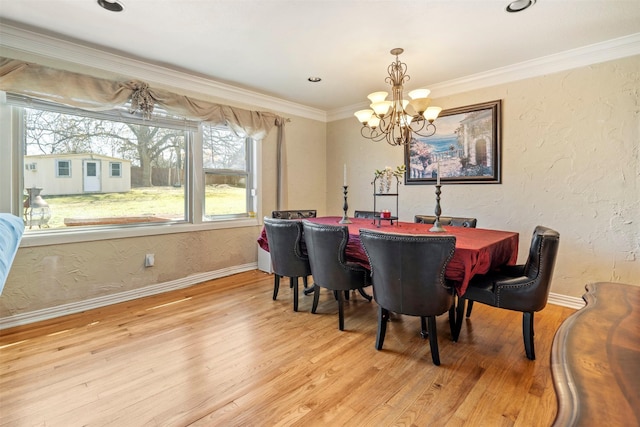 dining room featuring a textured wall, light wood-style flooring, and crown molding