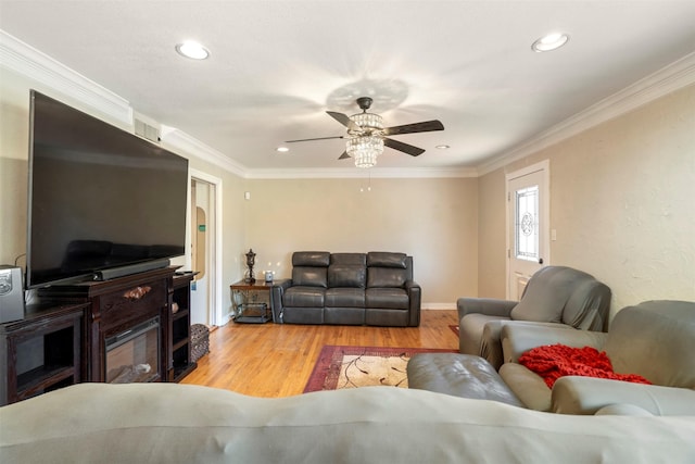 living area with light wood-type flooring, ornamental molding, a ceiling fan, and recessed lighting