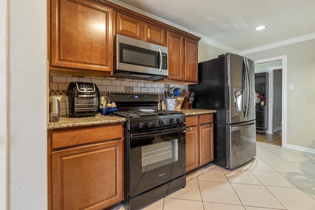 kitchen featuring light stone countertops, ornamental molding, stainless steel appliances, and decorative backsplash