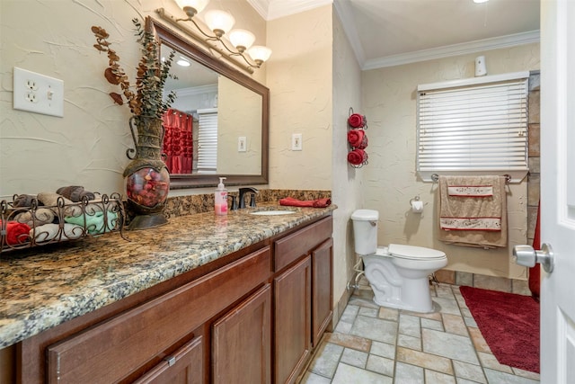 bathroom with a textured wall, vanity, stone tile flooring, and crown molding