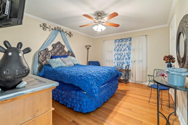 bedroom featuring ornamental molding, light wood-type flooring, and a ceiling fan