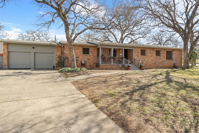 ranch-style home with brick siding, a porch, a garage, driveway, and a front lawn