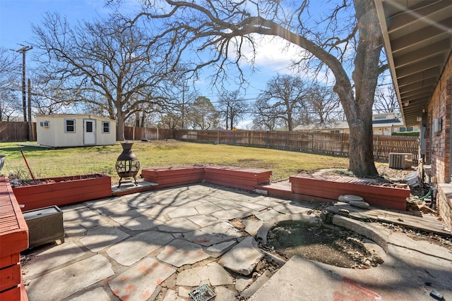 view of patio with an outbuilding, a fenced backyard, and central AC