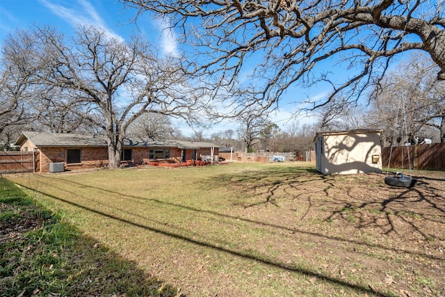 view of yard featuring a fenced backyard, an outdoor structure, and a shed