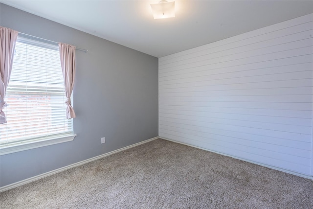 spare room featuring baseboards and carpet flooring