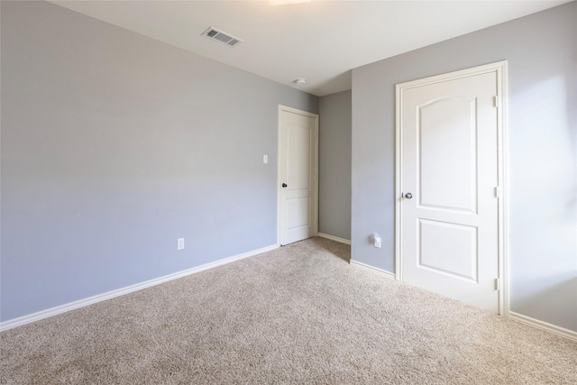 unfurnished bedroom featuring carpet, visible vents, and baseboards