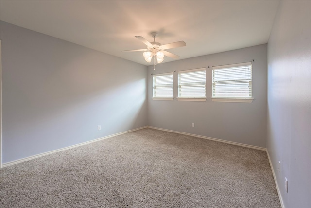 empty room with carpet floors, baseboards, and a ceiling fan