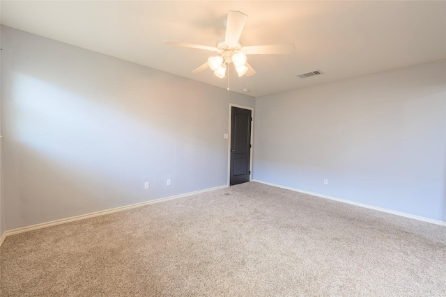 carpeted spare room with ceiling fan, visible vents, and baseboards